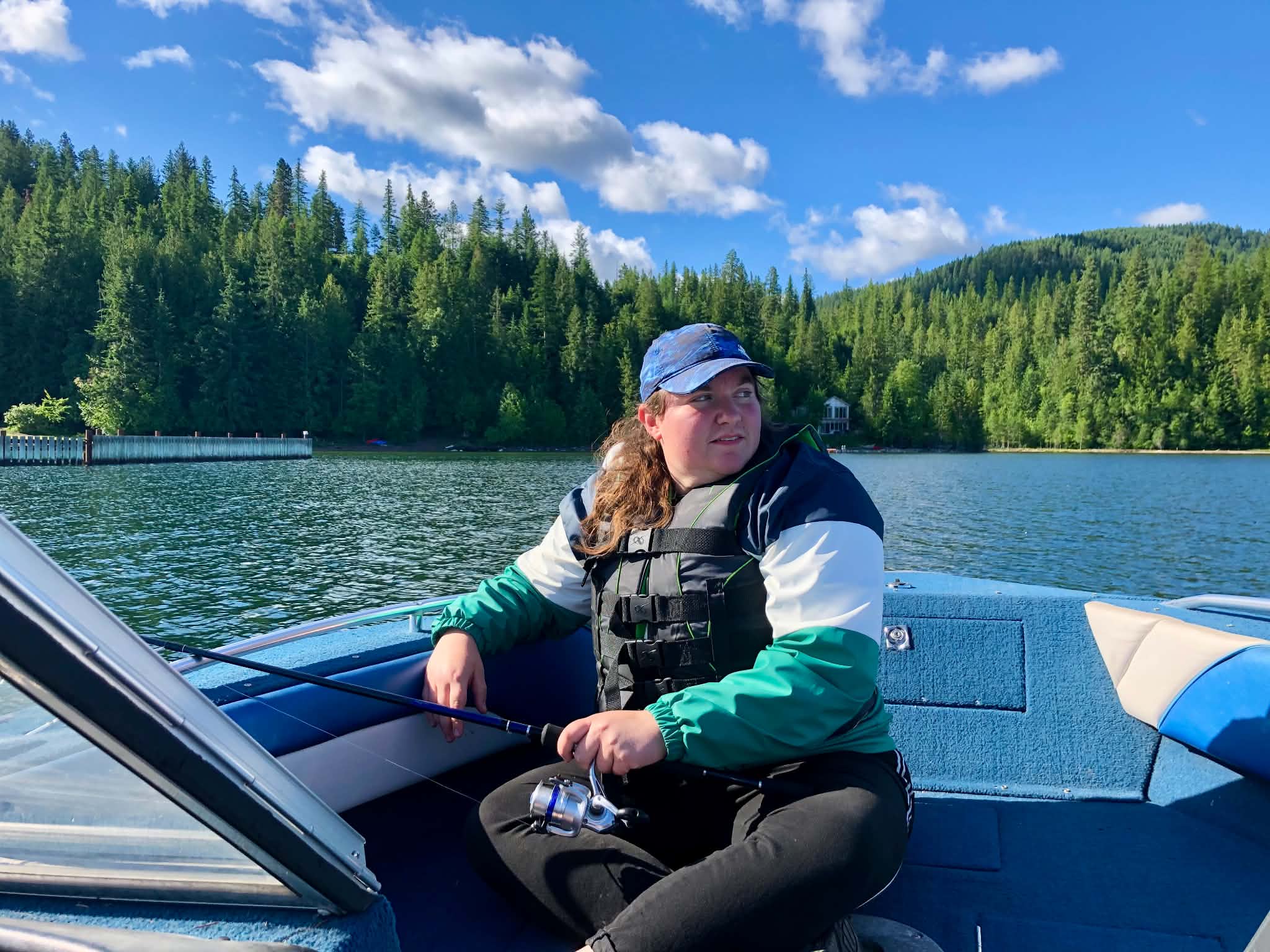 Bridgette fishing on a forest-lined lake
